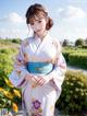 A woman in a kimono standing in a field of flowers.