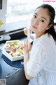 A woman sitting at a table with a box of food.