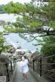 A woman in a white dress is walking up some stairs.